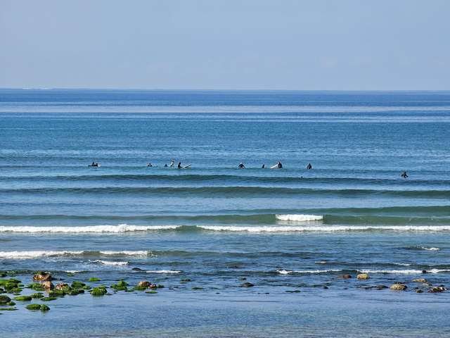 plenty of surfers in the water but too busy chatting to catch the glassy wave breaking in-shore of them